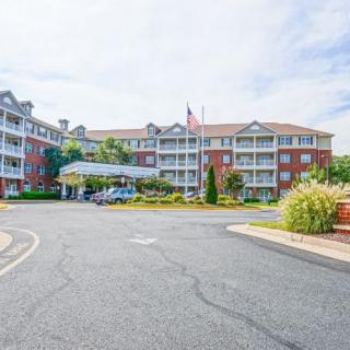 A multi-story residential building with American flags and landscaped surroundings.