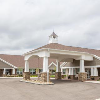A welcoming entrance to a hospitality facility under a cloudy sky.