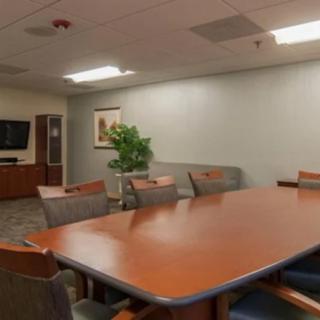 A well-lit conference room with a large meeting table and several chairs.