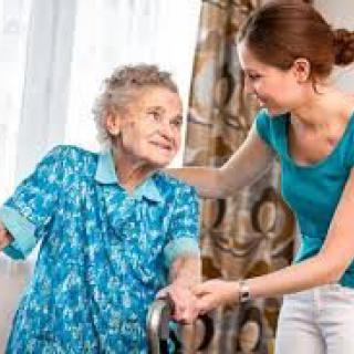 A caregiver assisting an elderly woman with mobility.