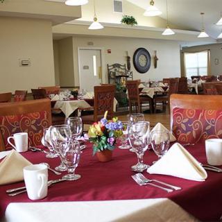 An elegantly set dining room with neatly arranged tables, complete with glassware and cutlery.