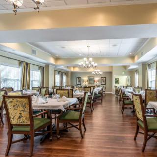 An elegant dining area with set tables and chandeliers.