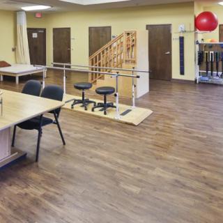 A rehabilitation room equipped with parallel bars and exercise equipment for physical therapy.