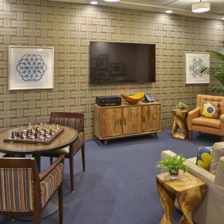 A cozy living room with a chessboard setup, featuring modern decor and wooden furnishings.