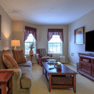 A cozy living room with a sofa, coffee table, and entertainment setup.