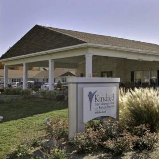 A single-story building with a prominent sign in the foreground, surrounded by well-maintained landscaping.