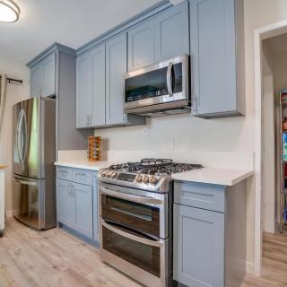 A modern kitchen featuring blue cabinets and stainless steel appliances.