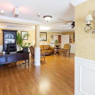 A well-furnished lobby area with wooden flooring, a sofa, and a decorative desk.