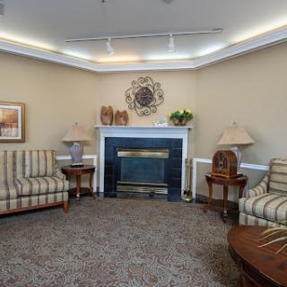 A cozy living room setup featuring striped sofas and a welcoming fireplace.
