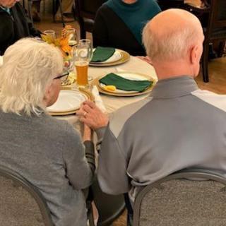 An elderly couple enjoys a meal together at a restaurant.