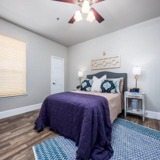 A cozy bedroom with modern decor and a ceiling fan.