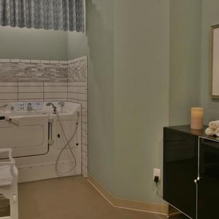 A bathroom with a tiled sink area and a sleek black cabinet.