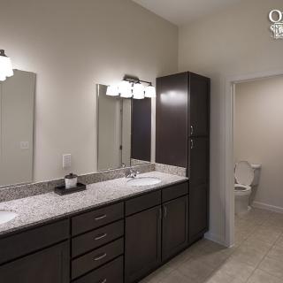Modern bathroom with double sink vanity and bright lighting.
