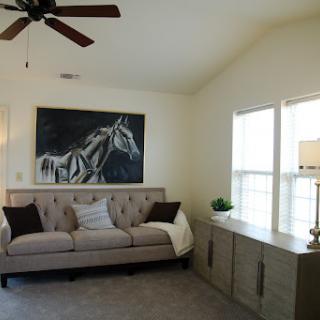 A cozy living room featuring a stylish sofa and a striking unicorn painting.