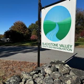 A sign for Blackstone Valley Land and Rehabilitation, set against a clear blue sky.
