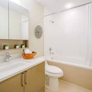 A modern and clean bathroom featuring a sink, toilet, and bathtub.