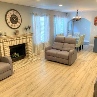 A cozy living room with a modern fireplace, comfortable seating, and a dining area.