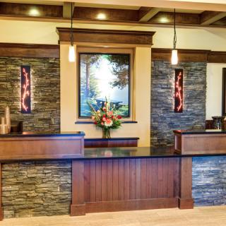 A modern reception area with stone walls, wood accents, and decorative lighting.