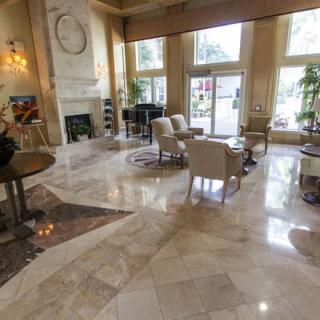 A spacious and elegant hotel lobby with marble flooring, comfortable seating, and large windows.