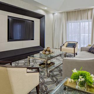 A modern living room with elegant furniture and a large television on the wall.