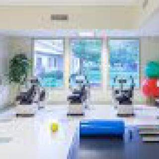 A well-equipped rehabilitation room featuring exercise equipment and colorful therapy balls.