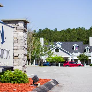 A welcoming entrance to a facility with neatly landscaped surroundings.