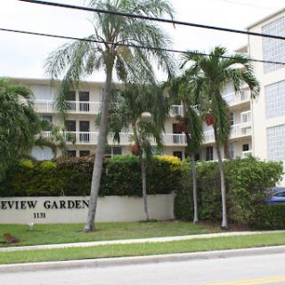 View of a residential apartment building surrounded by palm trees.
