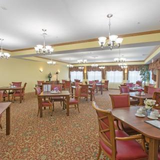 A spacious dining room with elegantly set tables and chandeliers.