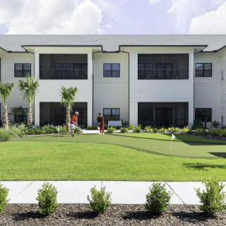 Modern residential building with a well-maintained lawn and landscaped surroundings.