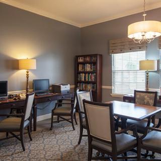 A well-furnished office space with computers and a meeting table.