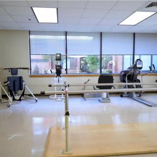 A well-lit physical therapy room with various gym equipment.