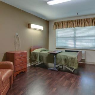 A hospital room with twin beds and wooden furniture.
