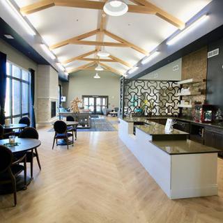 A modern cafe interior with wooden beams, comfortable seating, and a stylish counter.