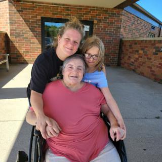 A heartwarming moment shared between a grandmother and her grandchildren, enjoying a sunny day together.