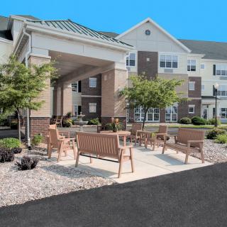 An outdoor seating area with benches in front of a residential building.