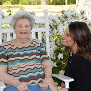 A joyful moment shared between a grandmother and her granddaughter in a beautiful outdoor setting.