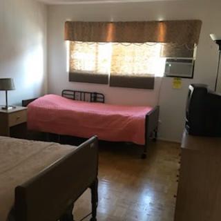 A cozy bedroom with a single bed, window, and essential furnishings.