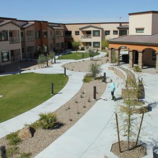 A landscaped courtyard in a residential apartment complex with walkways and greenery.