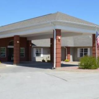 A front view of a building entrance with a driveway and flag.
