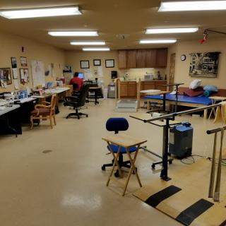 A spacious workshop filled with various workstations and tools, ready for creative projects.