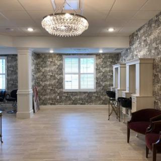A luxurious salon interior featuring hair stations and a sparkling chandelier.