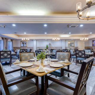 An elegant dining area with neatly arranged tables and chairs, showcasing sophisticated lighting and decor.