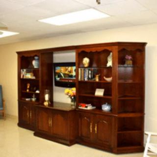 A spacious living room featuring a wooden entertainment center with bookshelves and a TV.