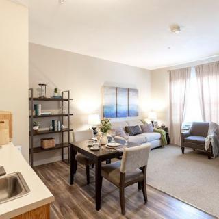 A modern apartment interior featuring a cozy living room and dining area with stylish decor.