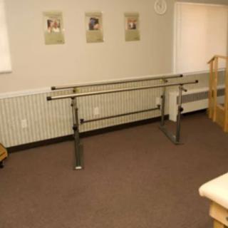 A therapy room featuring parallel bars for rehabilitation exercises.