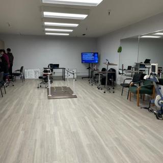 A modern office space with desks, chairs, computers, and a television.