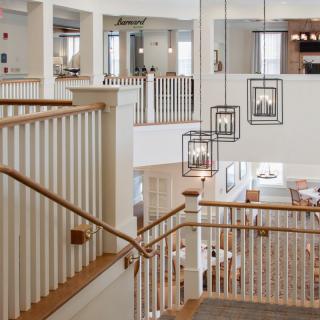 A modern interior featuring a staircase with elegant light fixtures and a spacious, open design.