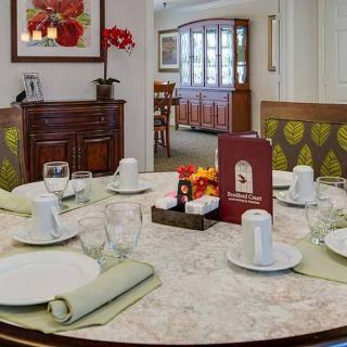 An elegantly set dining table with neatly arranged place settings and decor in a cozy dining room.