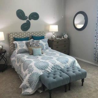 A stylishly decorated modern bedroom with teal and neutral color tones.