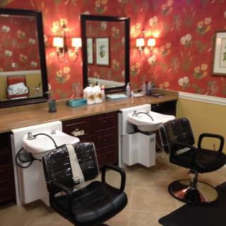 A stylish hair salon interior with two chairs, mirrors, and washing sinks.